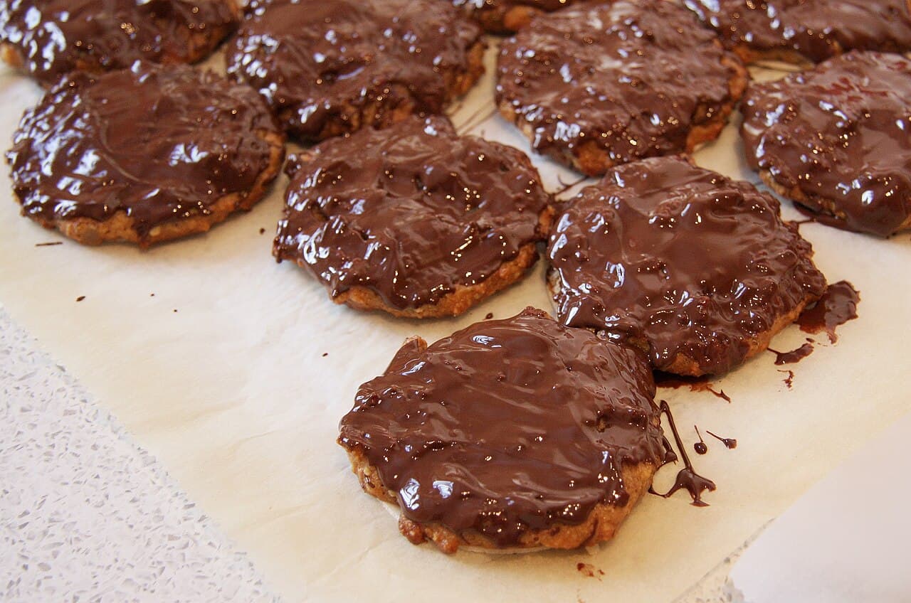 Frisch mit Schokolade überzogene Elisenlebkuchen liegen zum Trocknen auf Backpapier