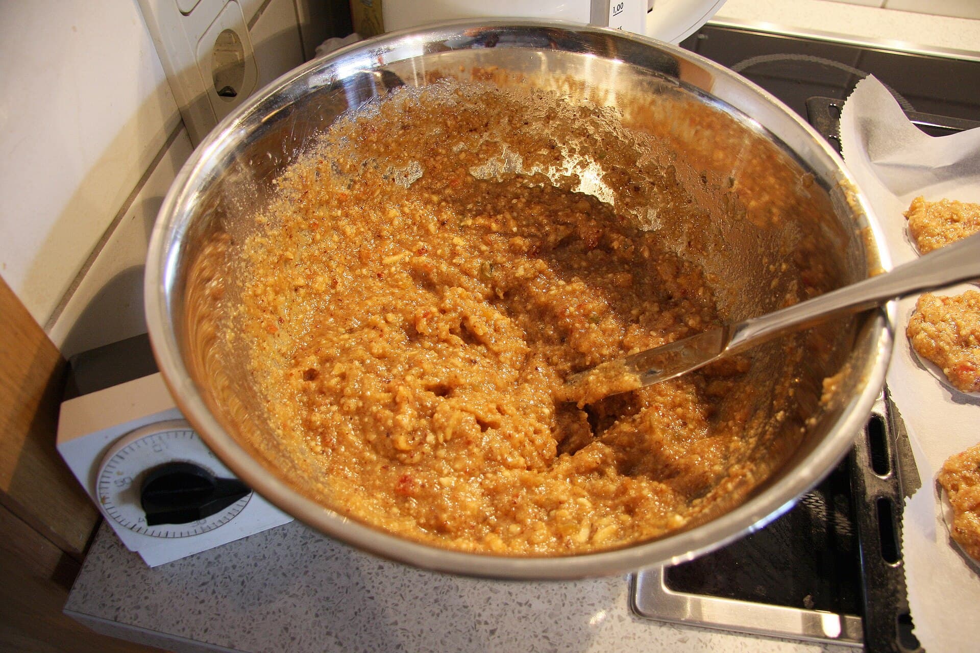 Schüssel mit Teig für Elisenlebkuchen aus Nüssen, Zucker und Gewürzen auf dem Herd