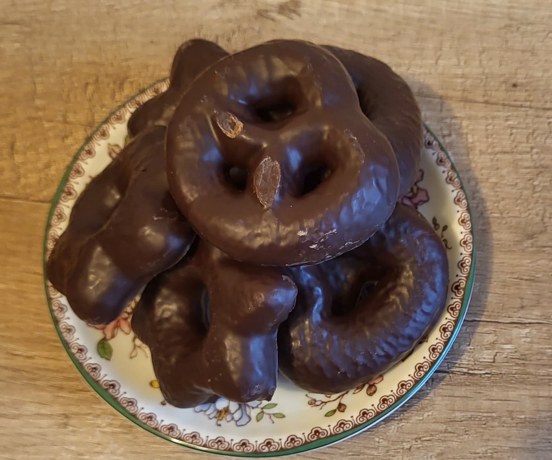 Lebkuchen Kalorien: ein Teller mit schokolierten Lebkuchen, darunter Brezeln, auf einem Holztisch